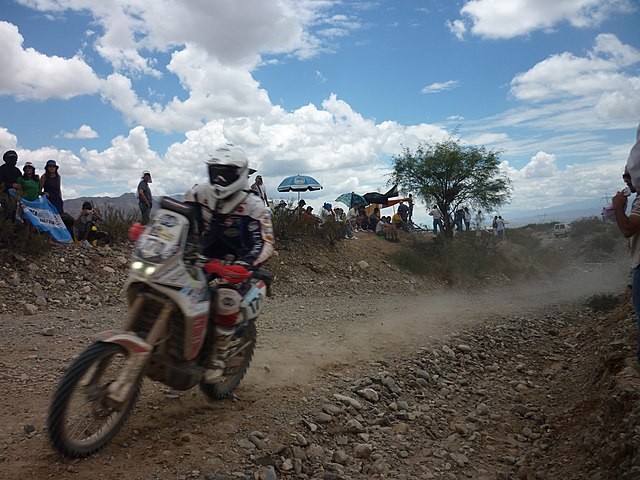 Uma motocicleta percorrendo uma estrada de terra durante o Rali Dakar 2012.