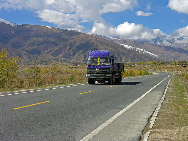 Um caminhão da DFM andando em uma estrada no Tibete.