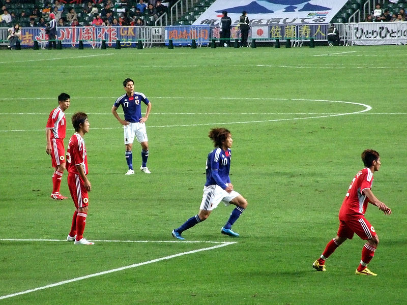 Uma partida de futebol entre China e Japão.
