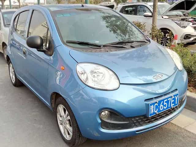 O Chery New QQ, em cor azul, parado em uma rua.