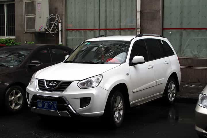 Um Chery Tiggo G2 branco parado em uma rua da China