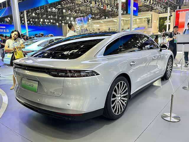 Novo Chery Celer branco visto de costas em uma mostra de automóveis.